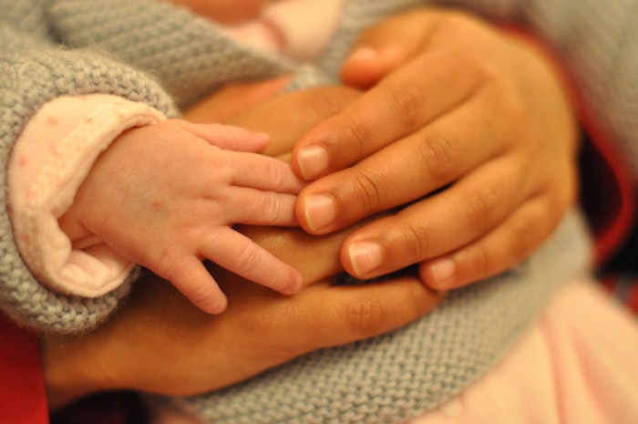 A baby reaching toward a caregiver