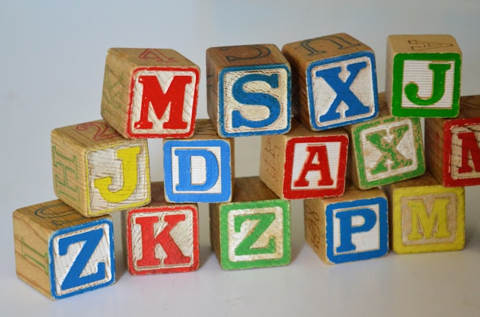 Wooden alphabet blocks and a child's hand