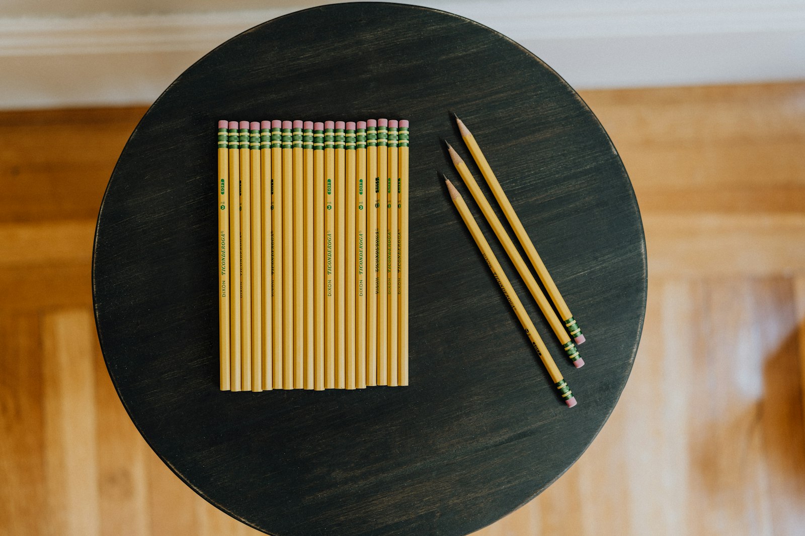 Sharpened pencils arranged on a small round table, overhead view